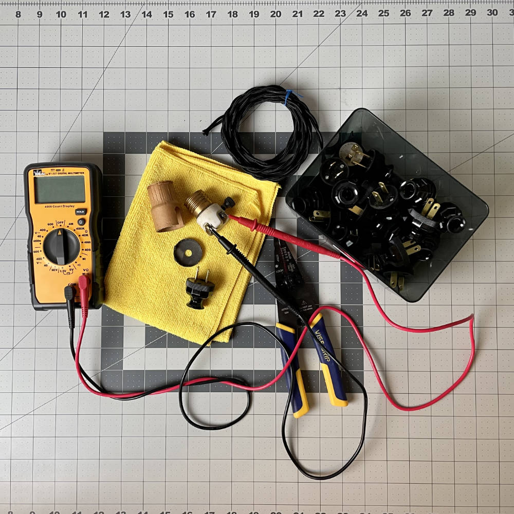 electrical components, wire, meter, plugs, sockets strewn across desk